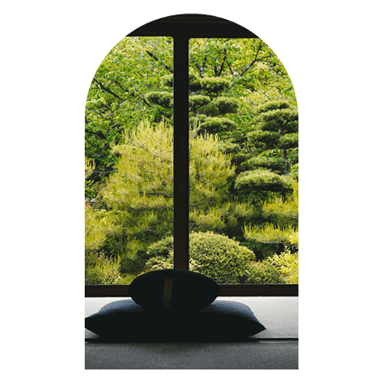 coussin de méditation devant une baie vitrée et un jardin japonnais